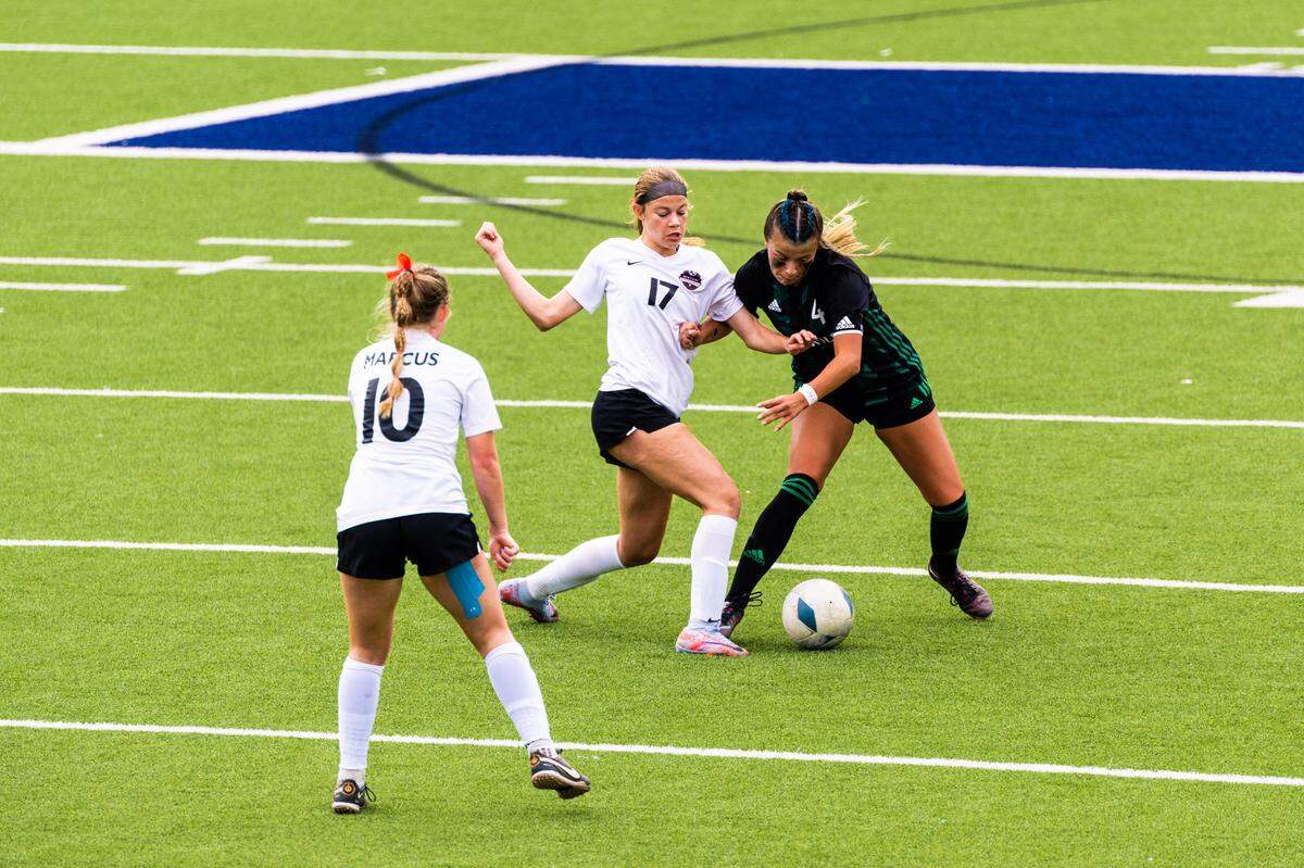 Southlake Carroll’s Kenzi Tufts (4) battles with Flower Mound Marcus’ Madi Patterson (17) and Allie Williams (10) during the Class 6A Region I final on Saturday, April 8, 2023 at McKinney ISD Stadium in McKinney, Texas. Marcus won 1-0 on an own goal.