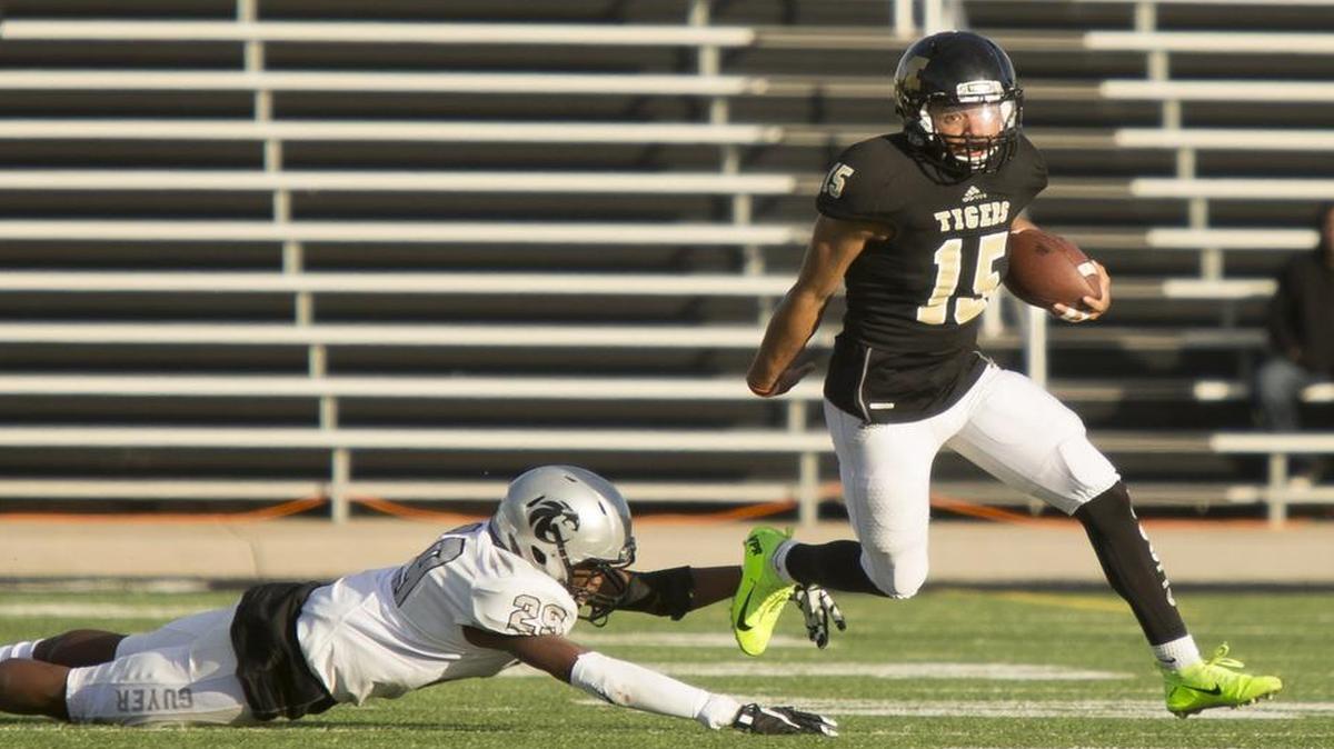 Mansfield quarterback Dameron Smith, right, brushes off a defender during the Tigers’ state quarterfinals victory over Denton Guyer. Smith and the Tigers will face Austin Lake Travis in a Class 6A Division II state semifinal at 2 p.m. Saturday.