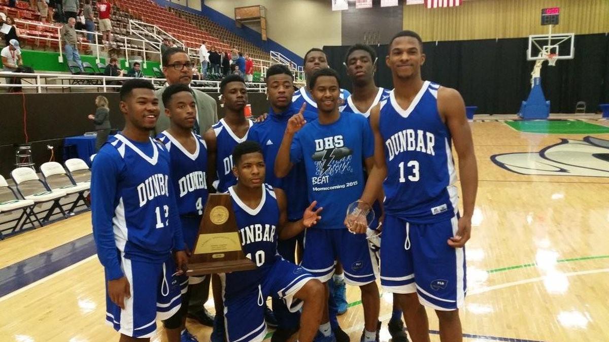Dunbar players and coach Robert Hughes Jr. celebrate the Wildcats 95-62 defeat of Wichita Falls Rider in the 5A Region I final at Western Texas College Coliseum in Snyder, Saturday March 5, 2016.