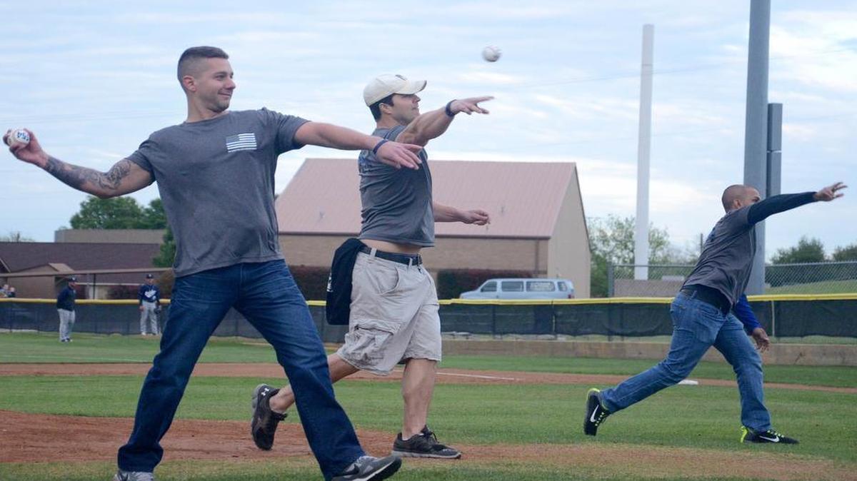 From left, Euless police officers Mike Sarro, Ed Pretrowski and Mo Karim toss out the ceremonial first pitches before the Euless Trinity-Hurst L.D. Bell baseball game. The three were co-workers in New York City and Euless with slain officer David Hofer.