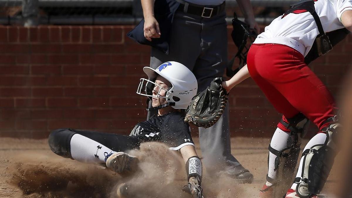Burleson Centennial Spartans base runner Eva Scott, left, scores ahead of the tag from Burleson Elks catcher Lauren Isbell (23) in the first inning. Centennial won 19-0.