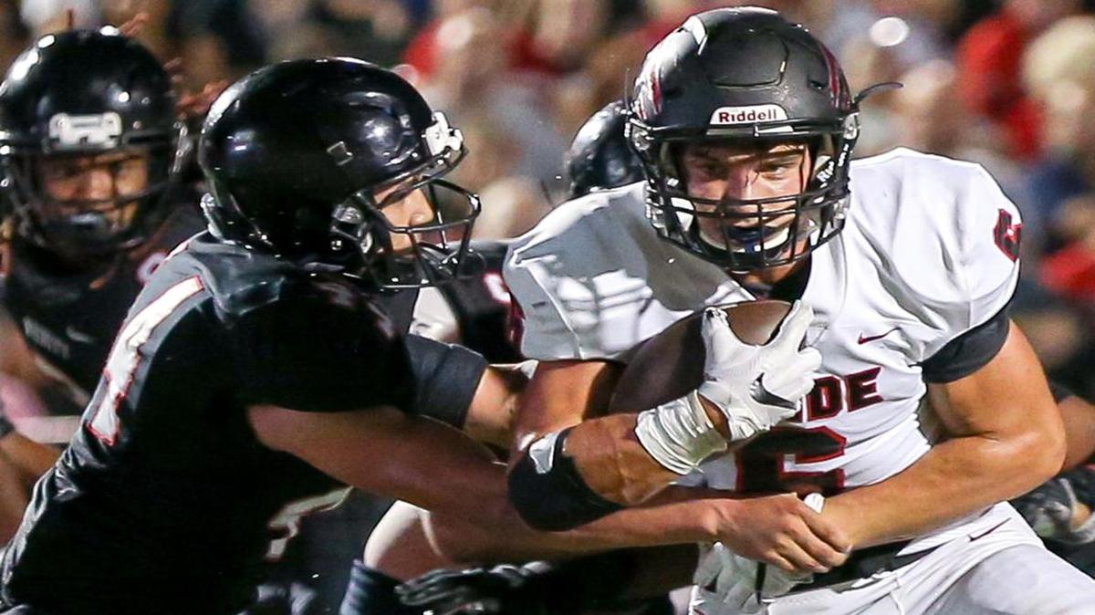 Colleyville Heritage running back Caleb Murphy (6) tries to break away from Trinity defensive end Isaiah Munoz (44) in Week 3 action.