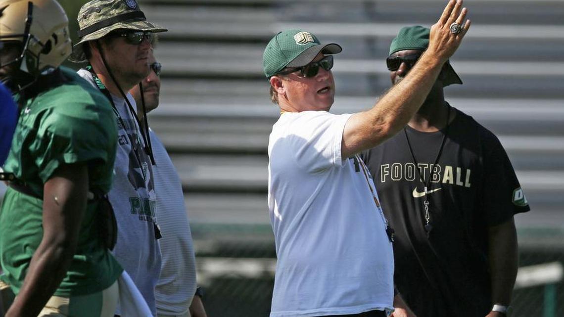 DeSoto head football coach Todd Peterman (right) talks to assistant coaches during 2017 spring practice.