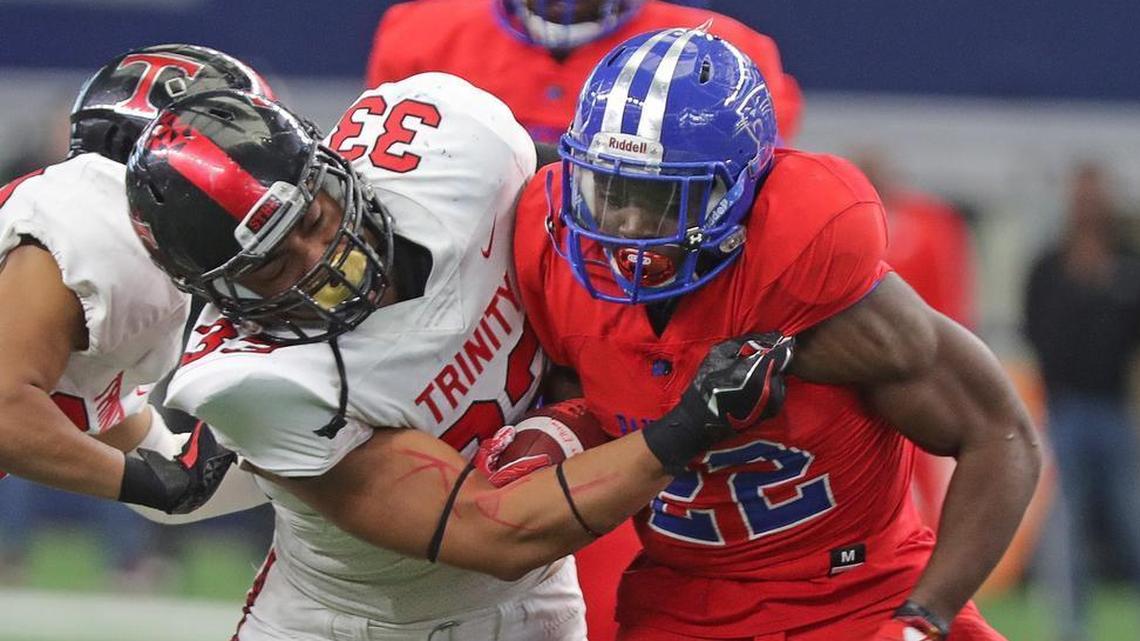 Euless Trinity defensive end Izaih Filikitonga wraps up on Duncanville running back Keilon Elder in a playoff game at AT&T Stadium, Nov. 25, 2017.
