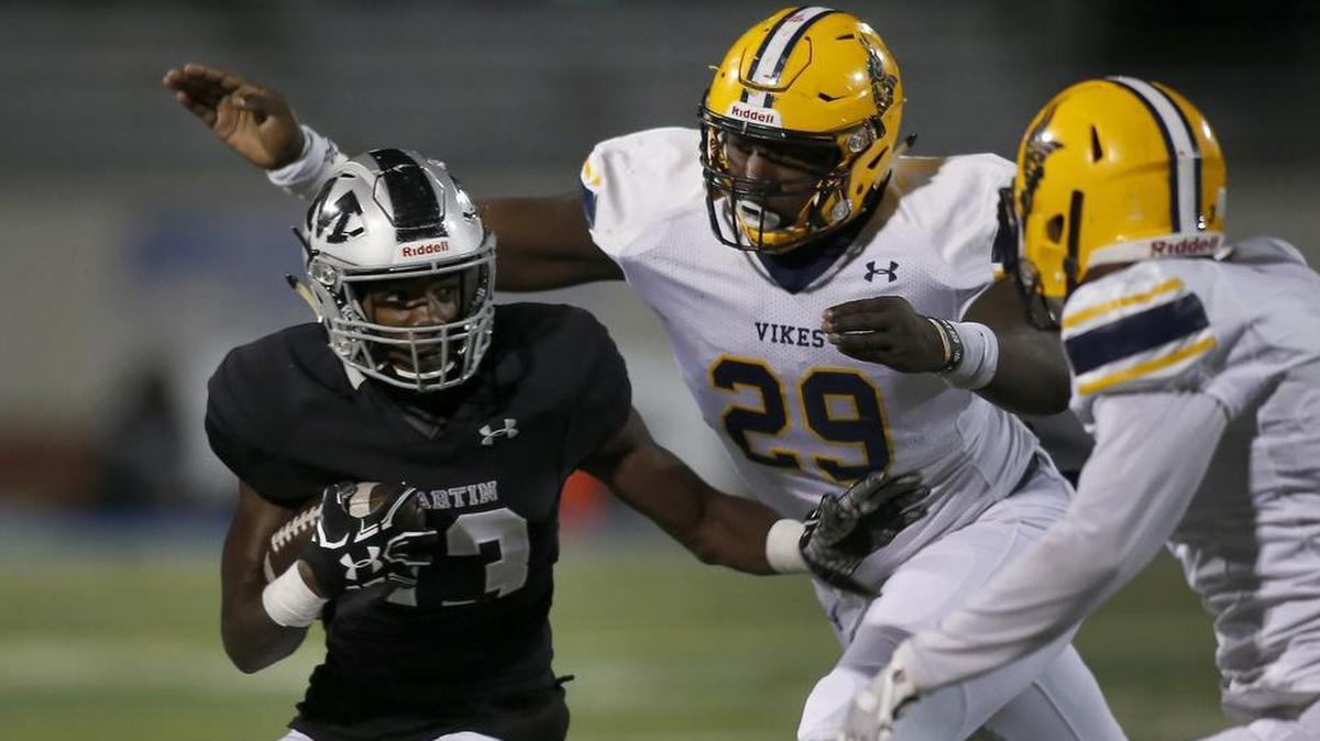 Arlington Martin running back Montrell Smith (13) is caught from behind by Arlington Lamar defensive lineman Bobby Brown (29) at Maverick Stadium in Arlington, Texas, Nov. 9, 2017.