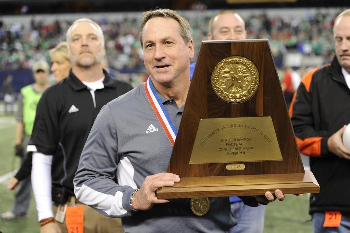 Aledo head coach Tim Buchanan displays the UIL championship trophy after the Bearcats defeated Brenham in 2013.