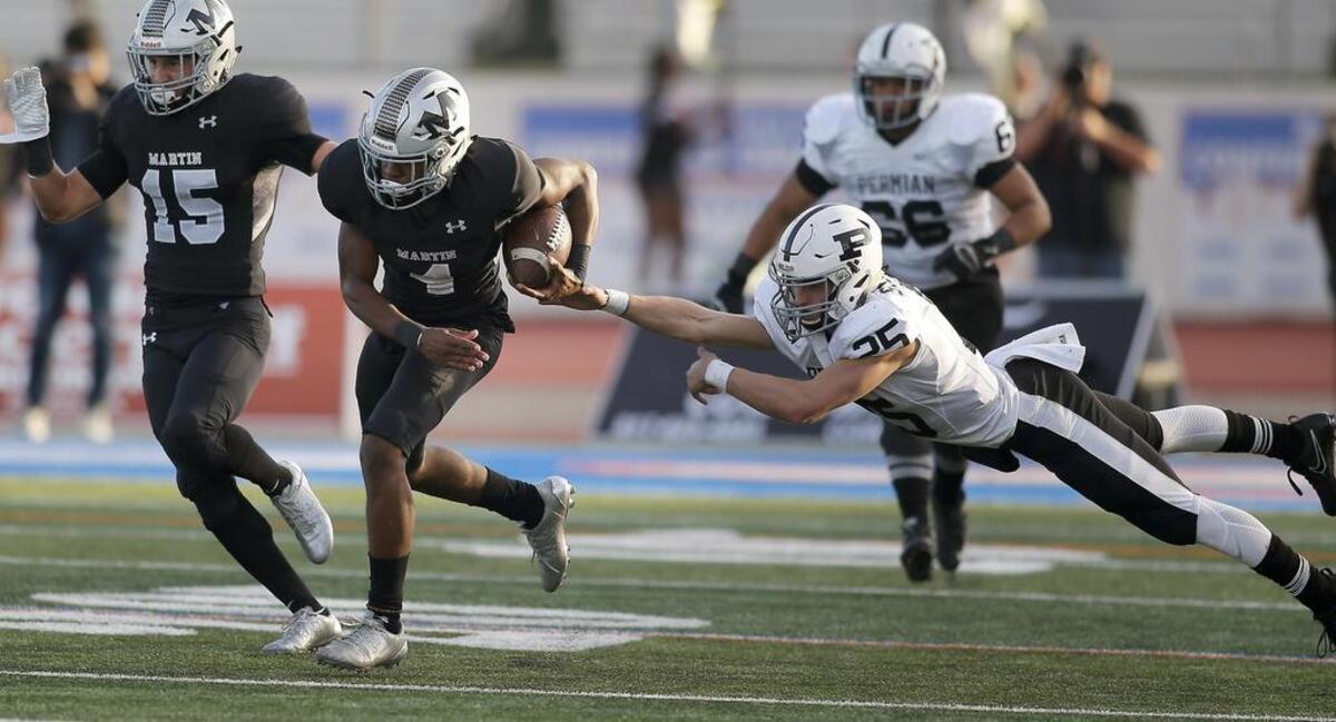 Arlington Martin Warriors safety Jayce Godley (4) returns a fumble 99 yards for a touchdown late in the first half of Friday’s high school playoff game at UTA Maverick Stadium. Permian quarterback Steve Steen (25) was unable to make the tackle.