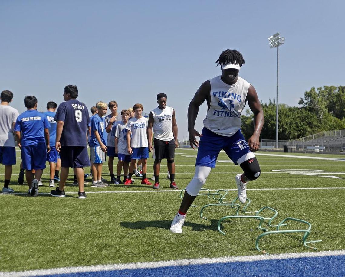 Hybrid outside linebacker NaNa Osafo-Mensah goes through drills during workouts with the Nolan Catholic High School Vikings Monday July 17, 2017. Workouts included agility and strength drills.