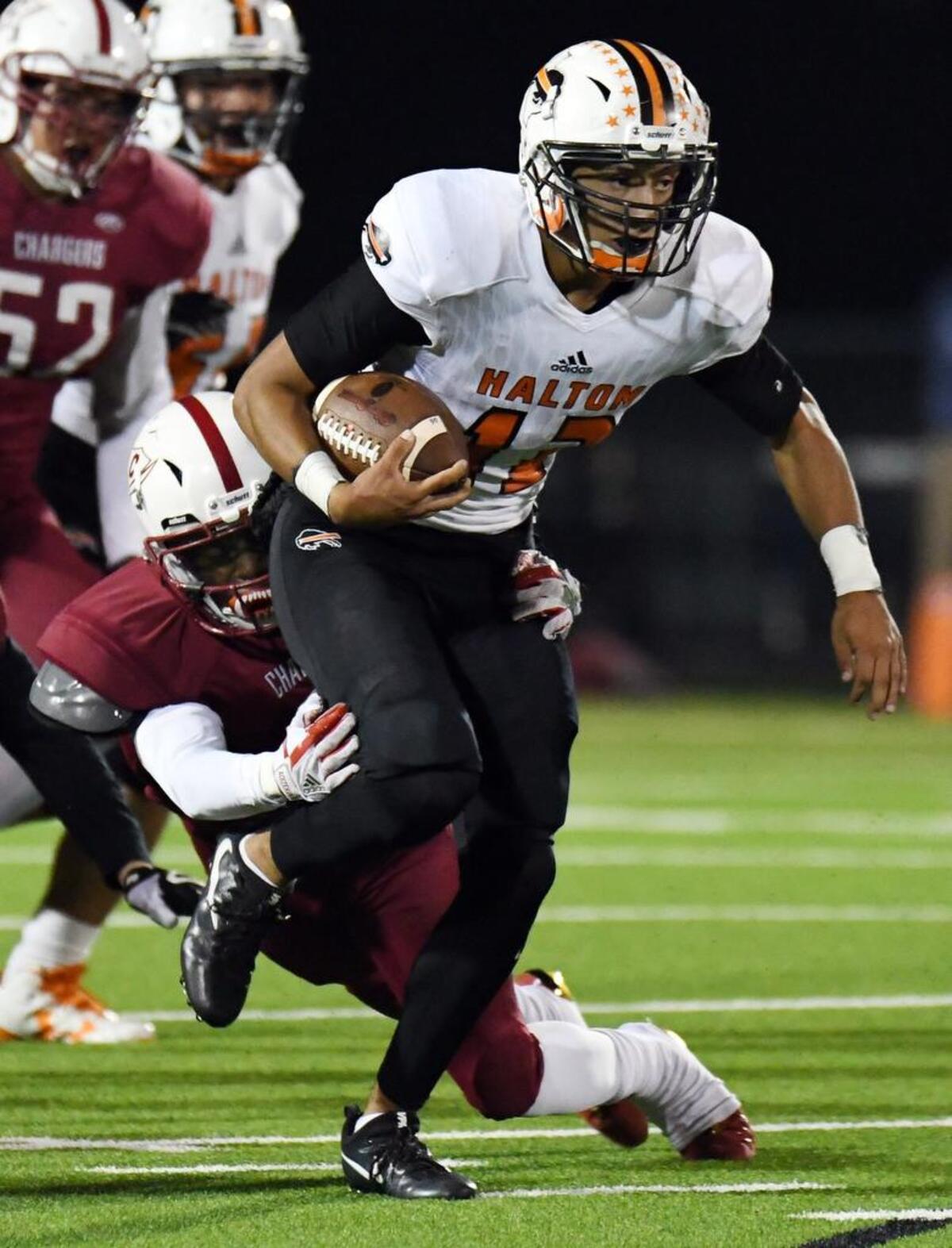 Keller Central's Stanley Coleman, left drags down Haltom quarterback Michael Black as he gets a first down in the second quarter.