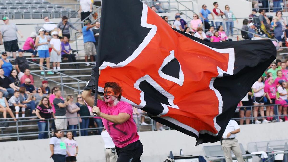 A member of the Aledo spirit team runs with the A in Aledo flag at the start of the game at Northwest ISD Stadium, October 15, 2016