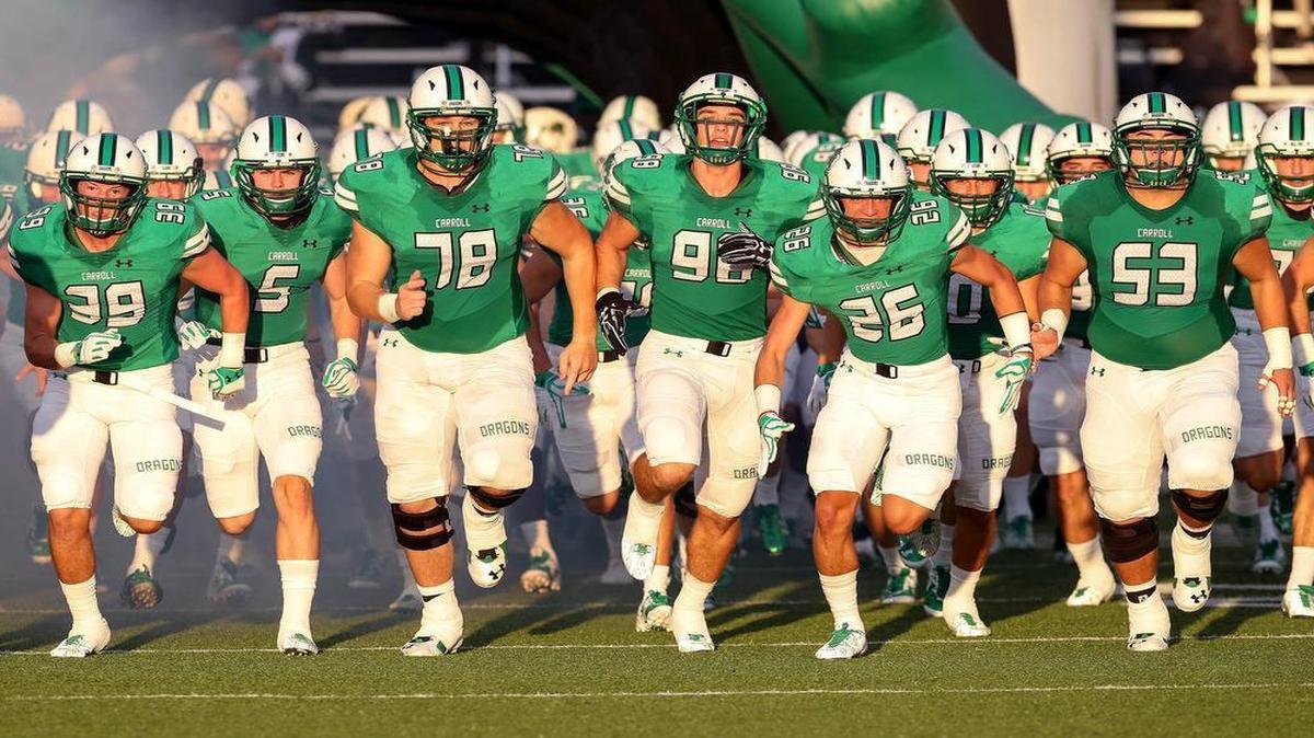 The Southlake Carroll Dragons enter the field before their game against Tulsa Union.