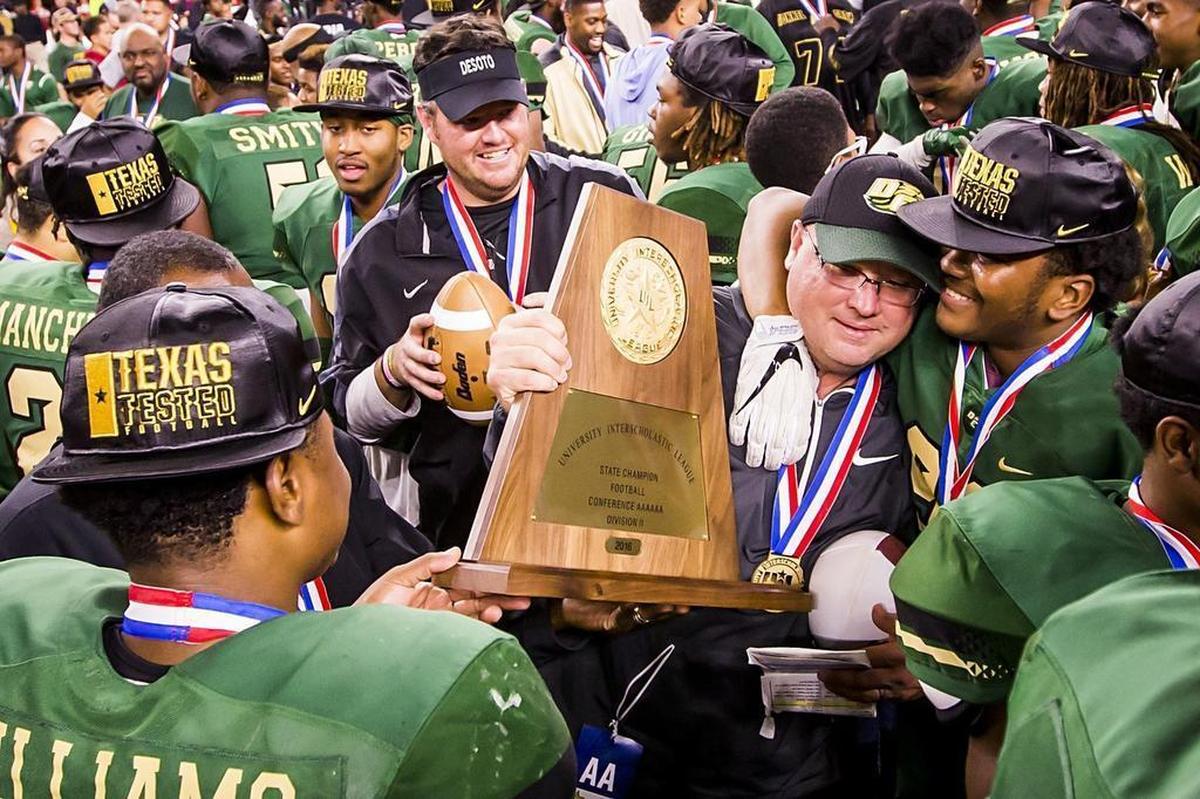 DeSoto head coach Todd Peterman clutches the UIL championship trophy as he celebrates with his players after the Eagles beat Cibolo Steele, 38-29, for the Class 6A Division II title at AT&T Stadium, Dec. 17, 2016.