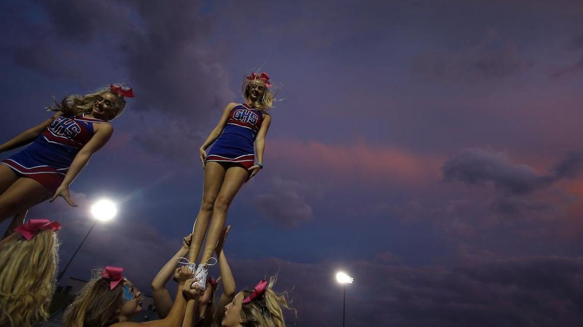 Grapevine Mustangs cheerleaders warm up before a high school football game.