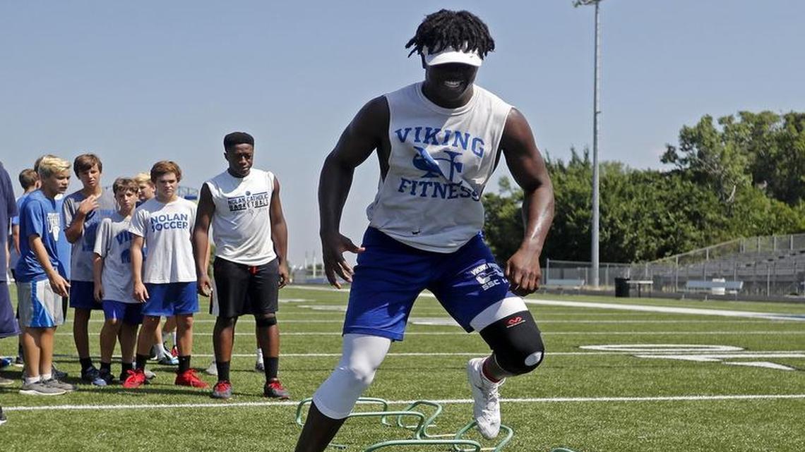 Hybrid outside linebacker NaNa Osafo-Mensah goes through drills during workouts with the Nolan Catholic High School Vikings Monday July 17, 2017. Workouts included agility and strength drills.