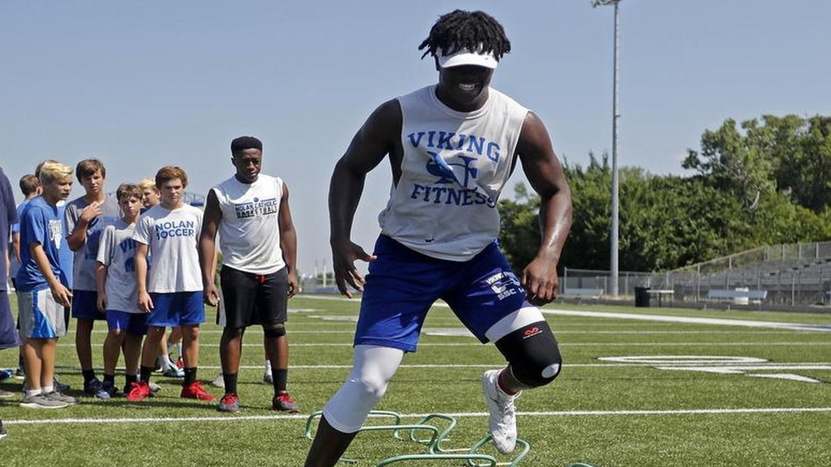 Hybrid outside linebacker NaNa Osafo-Mensah goes through drills during workouts with the Nolan Catholic High School Vikings Monday July 17, 2017. Workouts included agility and strength drills.