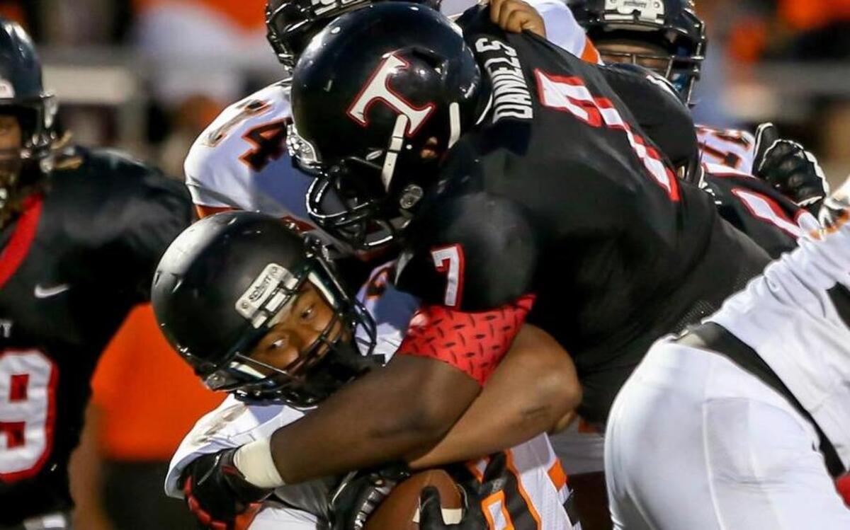 Lancaster RB Shannon Simpson (L) gets stopped for a loss by Trinity's Chris Daniels #7 during the 2nd quarter Thursday night, September 11, 2014 at Pennington Field in Bedford, TX.
