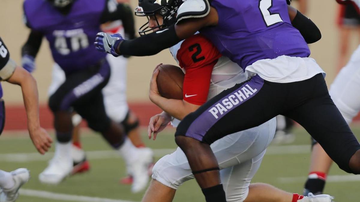 Burleson quarterback Hayden Whitten is tackled by Paschal defender JC Rispress after he picks up a first down in the first quarter.