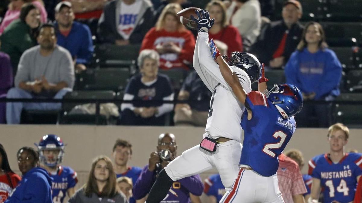 Fort Worth YMLA wide receiver Tyjuan Battles (2) extends to the ball as Grapevine defensive back Jordan Brooks-Wess closes in.