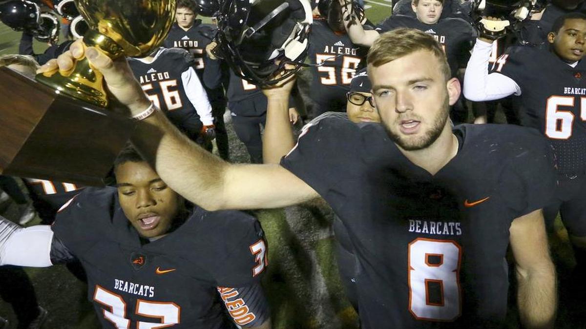Aledo quarterback Dillon Davis (8) holds the trophy as the team sings the alma mater after the 51-7 win over Grapevine in a high school football game Friday, November 18, 2016.