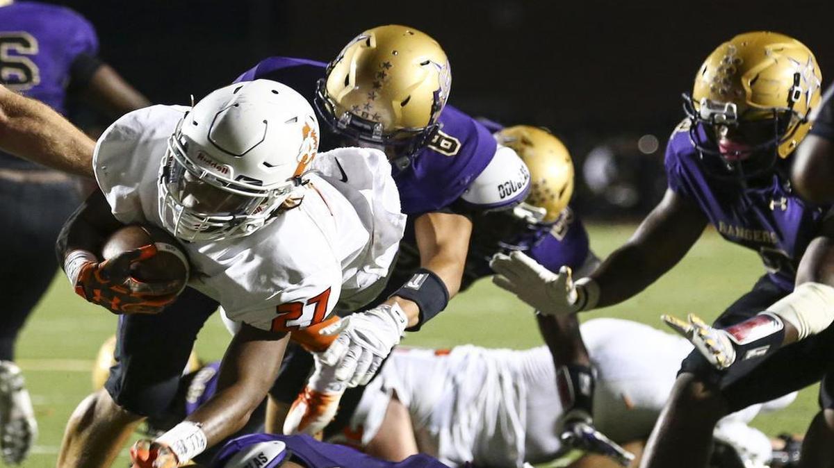 Donnie Evans (27) of Aledo dives past Chisholm Trail defenders for a touchdown.