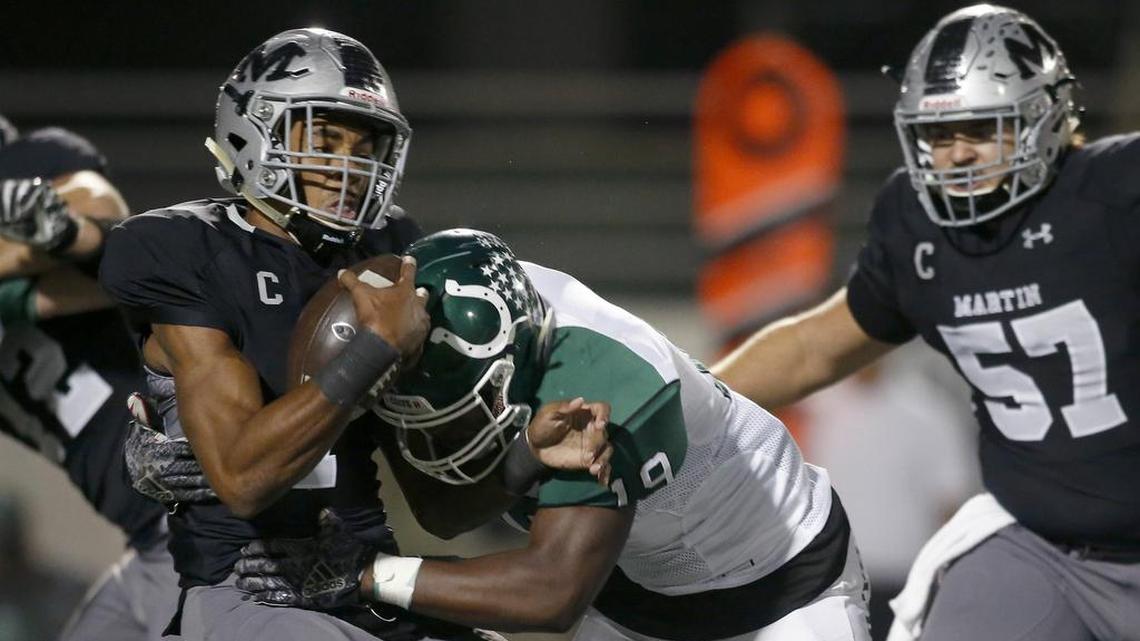 Arlington Martin Warriors quarterback Brayden Willis (7) is hit by Arlington Colts A’Tavion McDonald (19) short of a first down in the first half of a high school football game at Maverick Stadium.