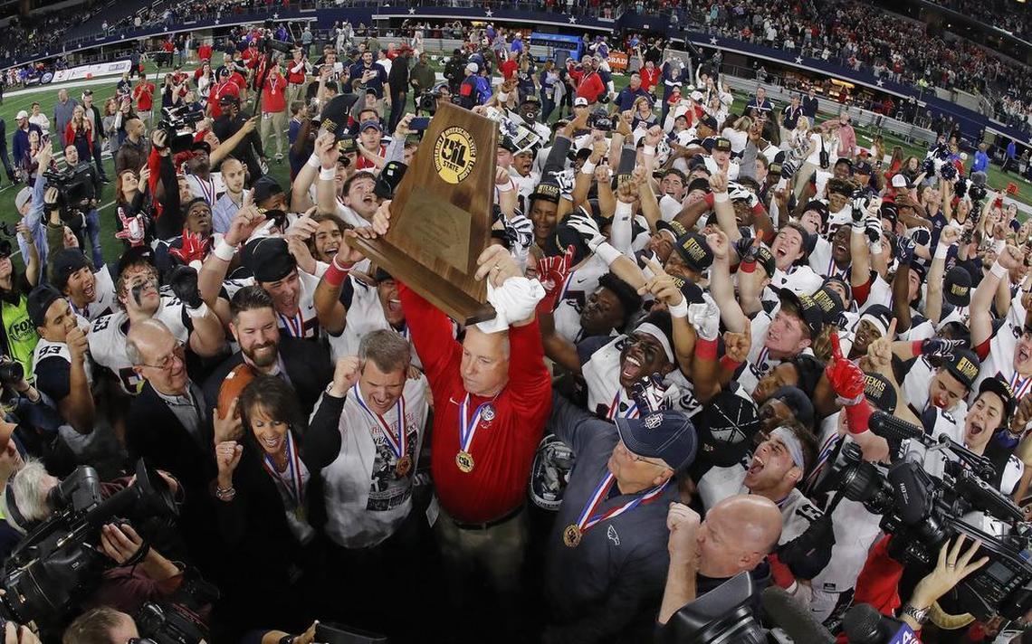 Allen head coach Terry Gambill holds the UIL state championship trophy up after Eagles beat Austin Lake Travis, 35-33, for the Class 6A Division I title at AT&T Stadium, Dec. 23, 2017.