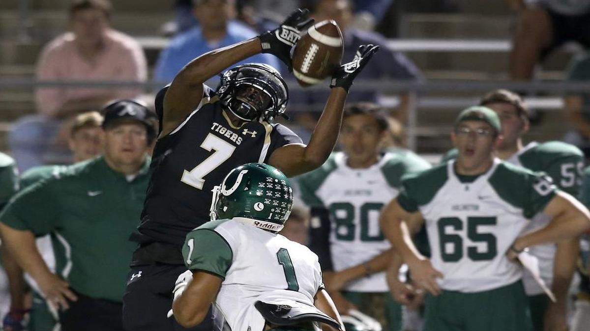 Mansfield Tigers receiver Saiid Adebo (7) makes a reception over Arlington Colts defensive back Darien Ruffin (1) in the first half of a high school football game at Newsom Stadium in Mansfield, Texas on Friday, Sept. 30, 2016.