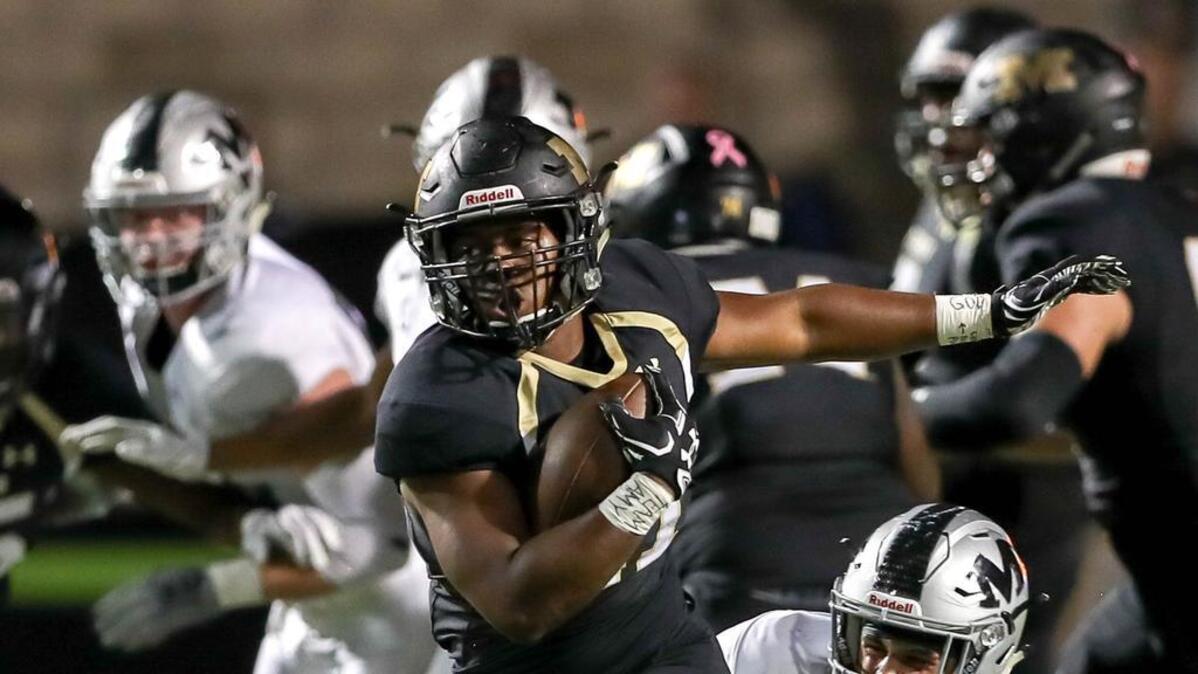 Mansfield running back Theo Owens (21) tries to get past Martin defensive back Basel Abu-Ahmad last month.