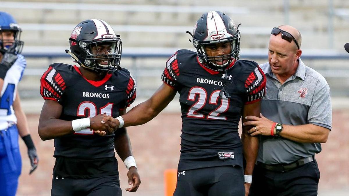 Mansfield Legacy running back Grant Johnson (22) is helped off the field by head coach Chris Melson and Isaiah Jones (L) after scoring a touchdown in December. He and Melson are up for awards from the 1st Down Club.