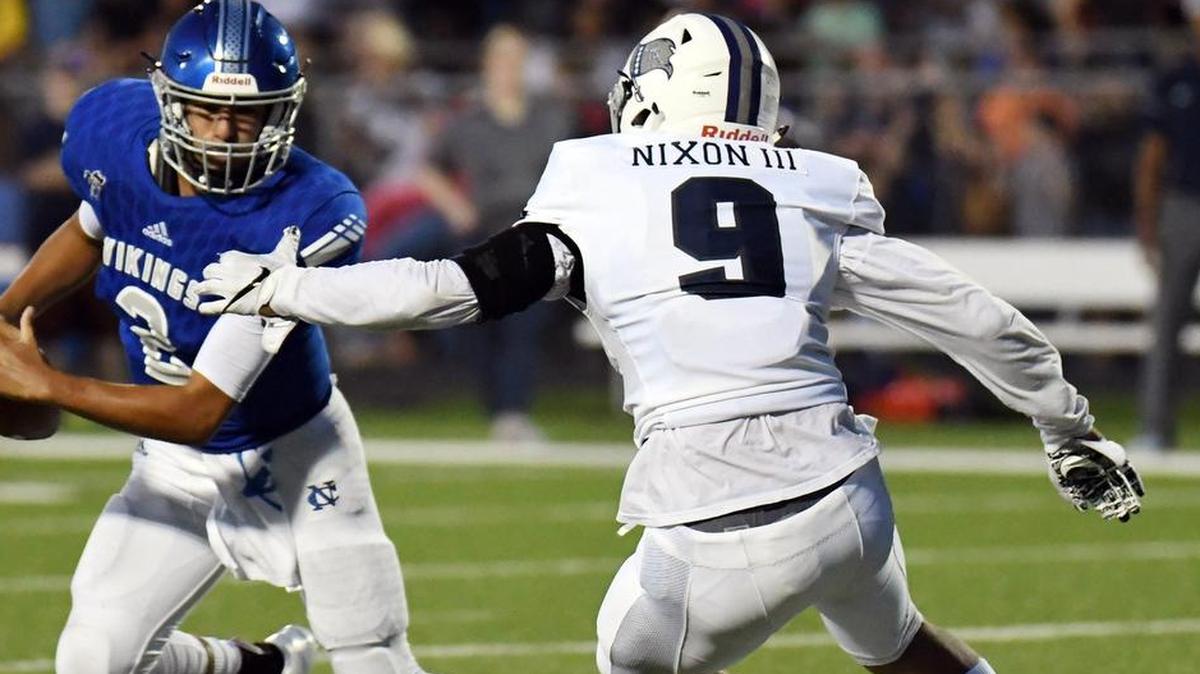 Nolan Catholic quarterback Luke Macias, left, is pursued by Richland’s Larry Nixon III in a Week 1 game.