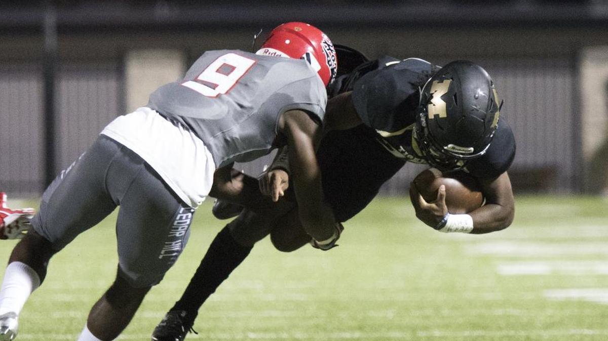 Mansfield running back Avery Chatman (32) dives for extra yards as Cedar Hill’s Cameron Jones (9) closes in, Sept. 8, 2017.