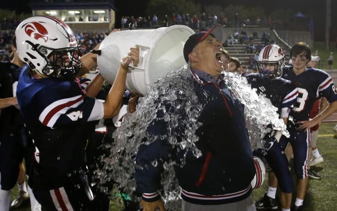 Country Day quarterback Brad Chilcoat, right, dumps ice water on coach Frank Gendusa late in the second half of the Class 3A SPC Championship game against the Cistercian Hawks at McNair Stadium in Fort Worth. Country Day won 52-17.