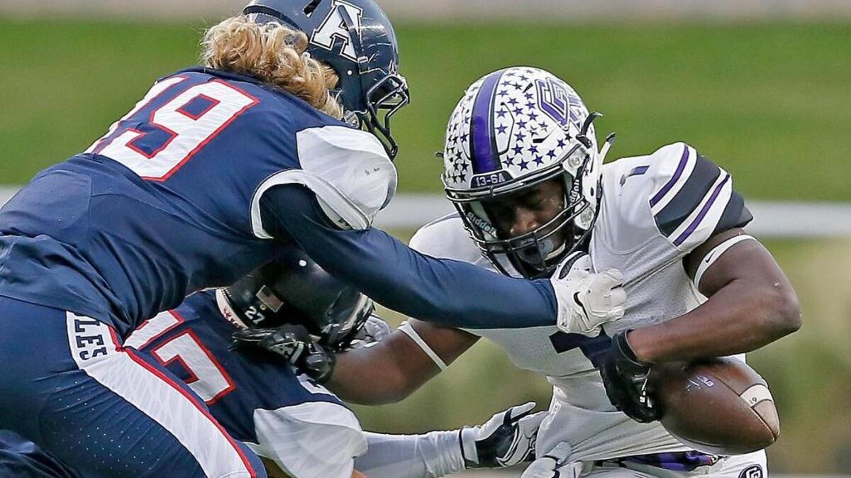 Allen’s Luke Jaksick (19) and Alex Schneider (27) pressure Trey Williams of Cedar Ridge into a fumble during the first half Saturday in Waco.