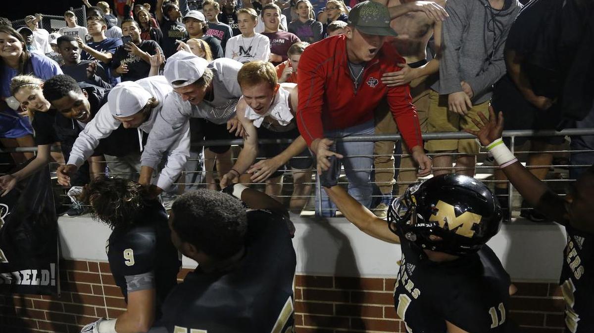 Mansfield Tigers fans celebrate with players following a 46-43 win against Cedar Hill in October 2015 that clinched the Tigers’ first district championship in more than 40 years. Oct. 29, 2015. Cedar Hill won Sept. 2 when the teams met in nondistrict after 2016 relignment.
