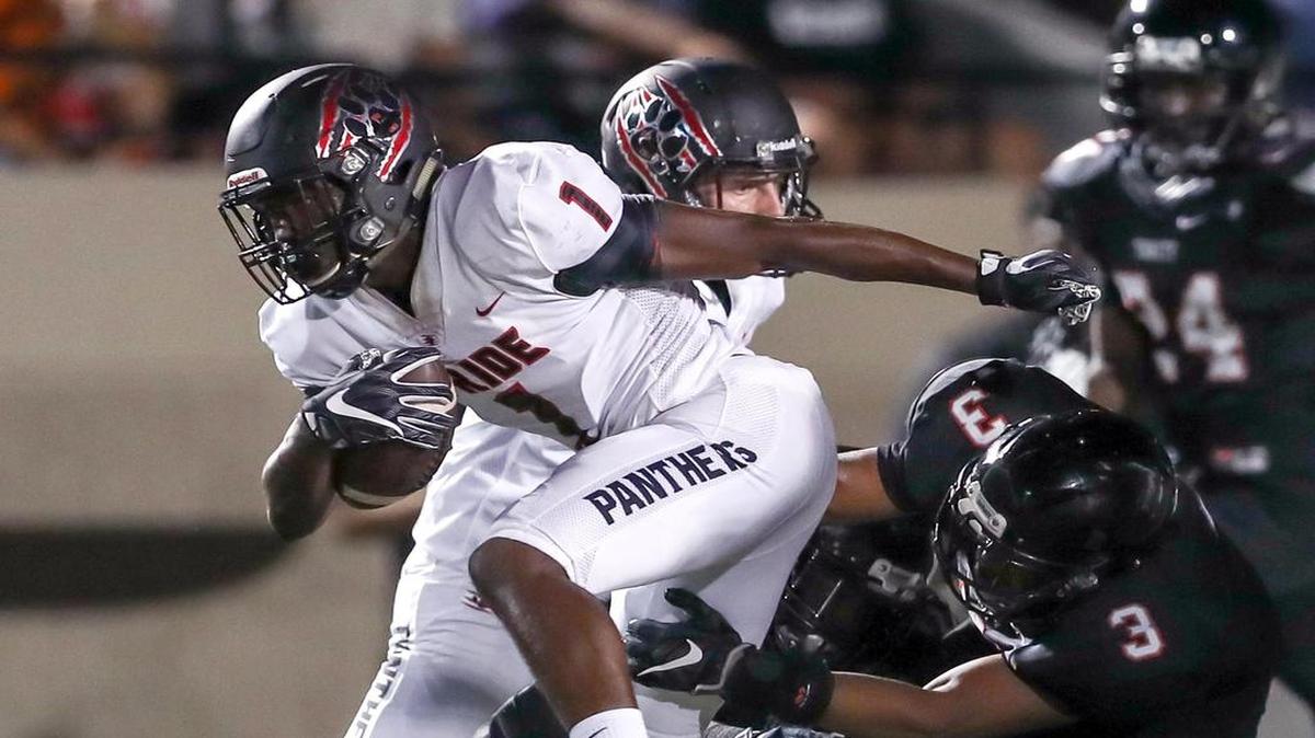 Colleyville Heritage wide receiver Ke'von Ahmad (1) tries to break a tackle from Trinity line backer Brandon Theus (3) in Week 3.