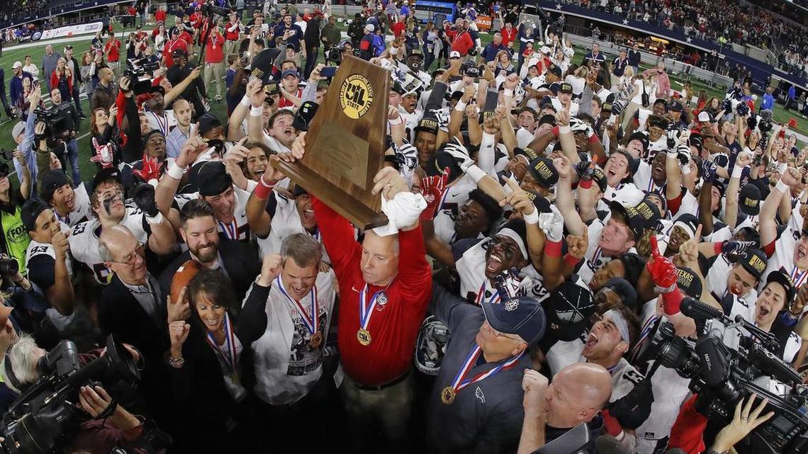 Allen head coach Terry Gambill holds the UIL state championship trophy up after Eagles beat Austin Lake Travis, 35-33, for the Class 6A Division I title at AT&T Stadium, Dec. 23, 2017.