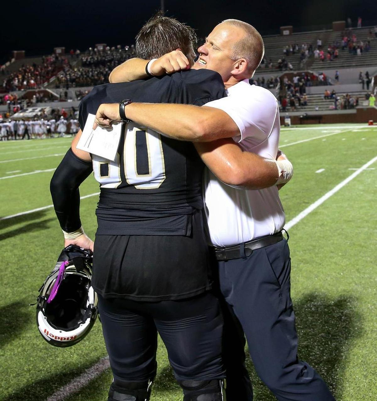 Mansfield head coach Daniel Maberry gives a big hug to Grayson Schramme after the Tigers beat Arlington Martin, 27-16, Oct. 13, 2017.
