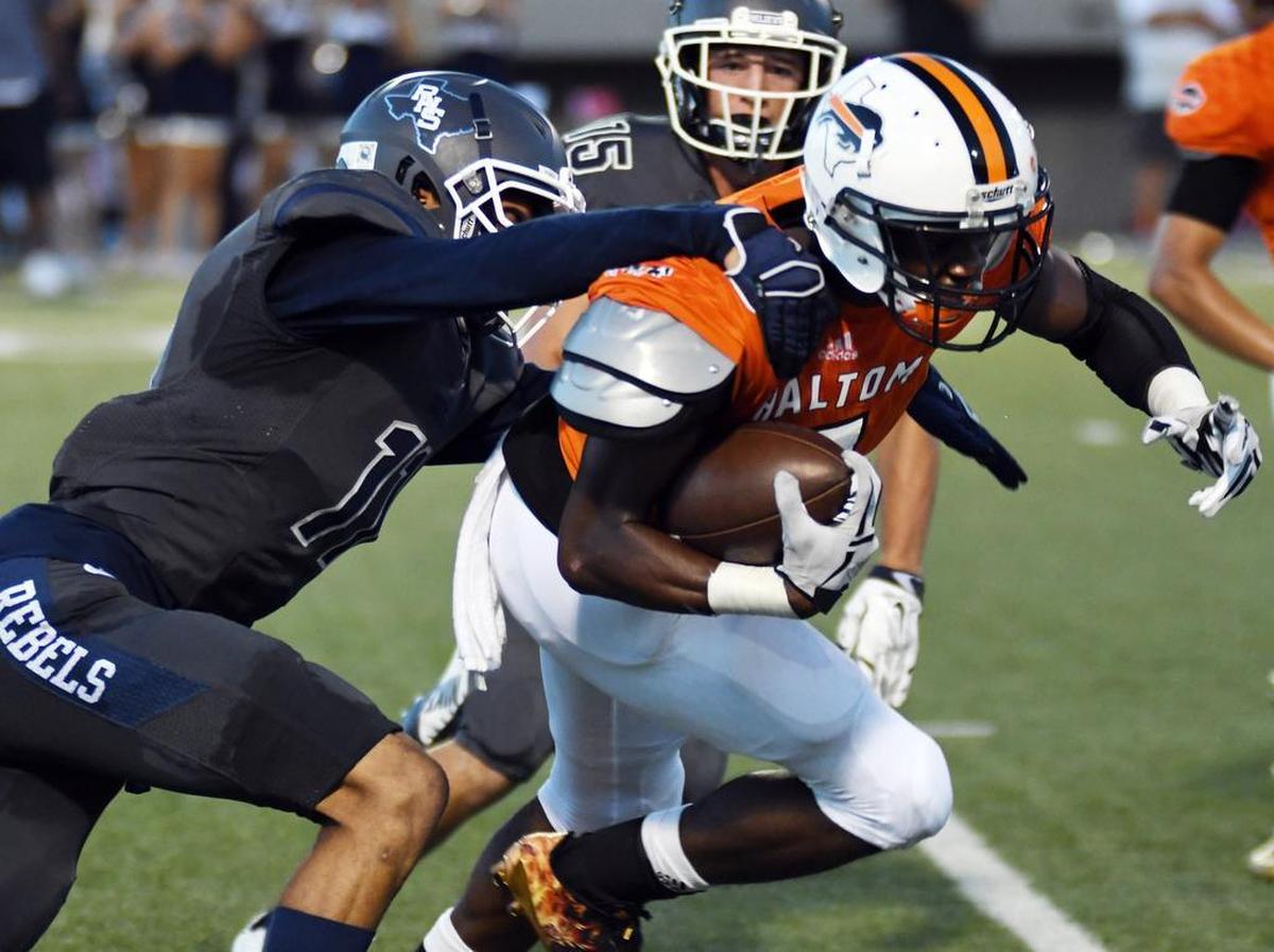 Richland’s Kyle Itoka, left, grabs Haltom’s Jeffon Evans from behind.
