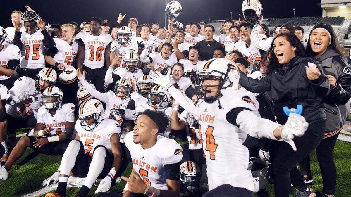 The Haltom football team and supporters pose for a celebratory picture on the field after their playoff-qualifying 28-17 win against Keller Central on Thursday.