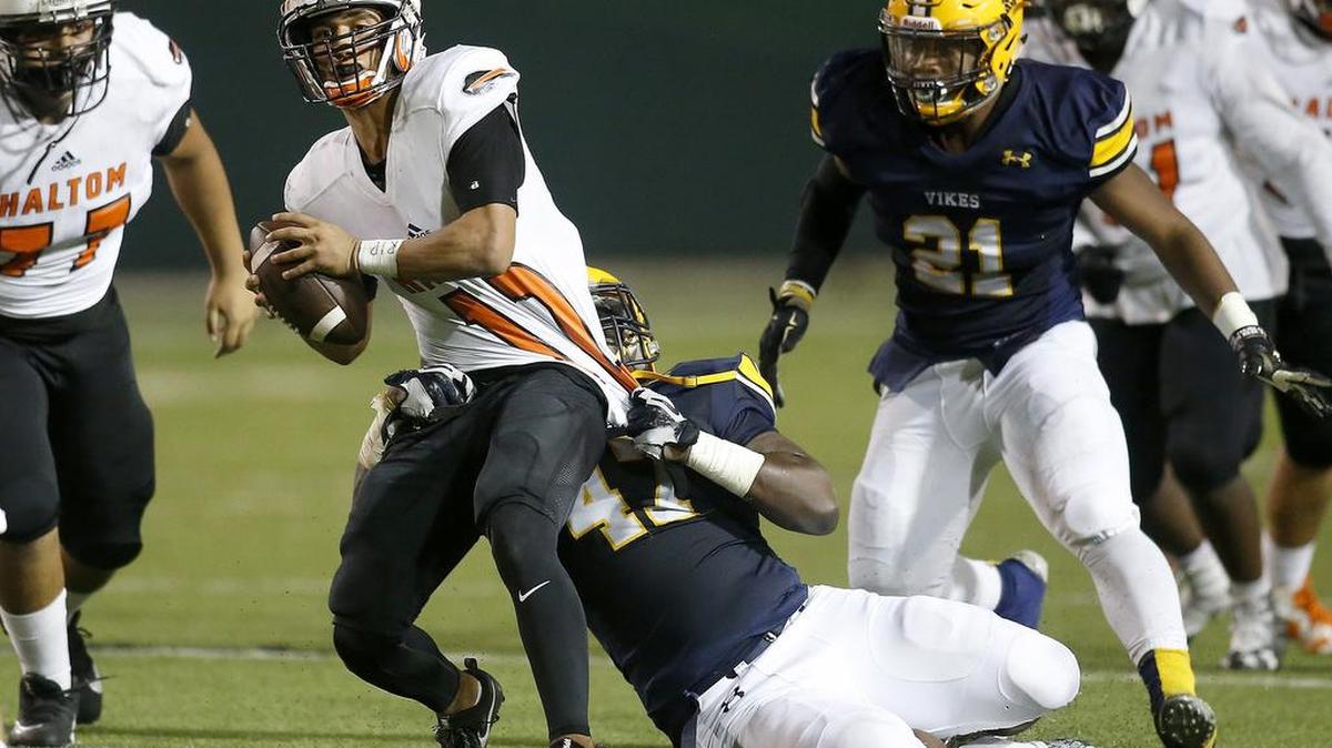 Haltom Buffalos quarterback Michael Black (12) is tackled from behind by Arlington Lamar Vikings defensive lineman Kesswin Kinney (47) in the first half of a high school playoff football game at the Gopher-Warrior Bowl in Grand Prairie, Texas on Thursday Nov. 16, 2017.