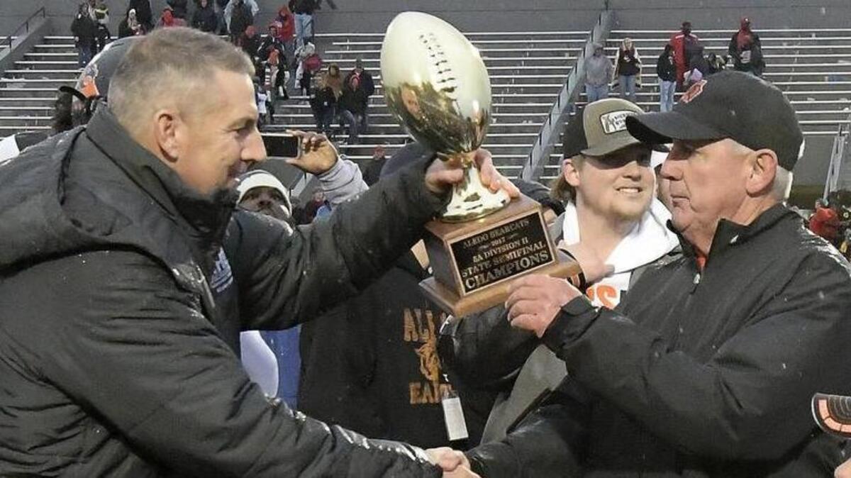 Aledo football coach Steve Wood is presented with a state semifinal trophy after the Bearcats beat Mansfield Legacy 28-21 at Pennington Field.