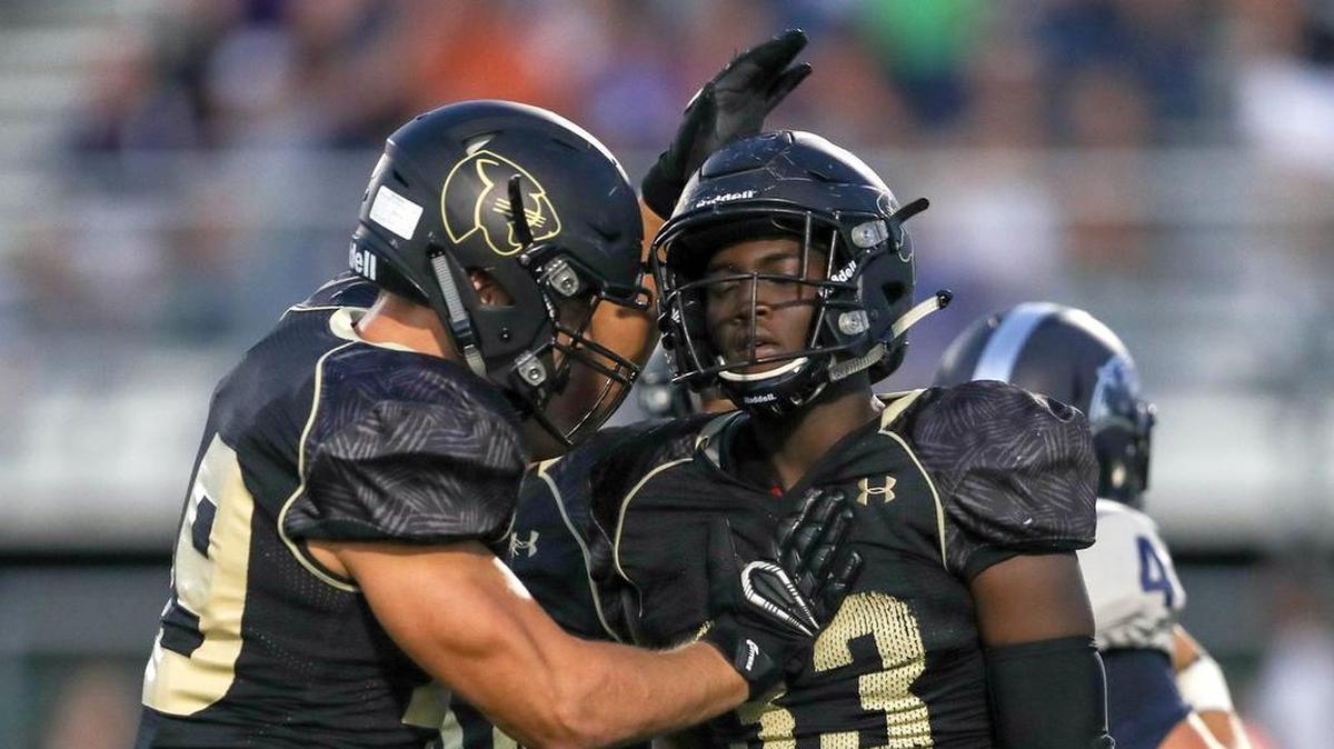 Keller Fossil Ridge’s Klein Mulongo (33) is greeted by Arnold Saidov after Mulongo's sack against Flower Mound in early September.