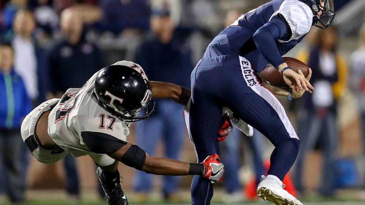 Trinity safety Cam’ron Jones (17) tries to taclke Allen QB Mitchell Jonke (R) during a playoff game in Allen last season.