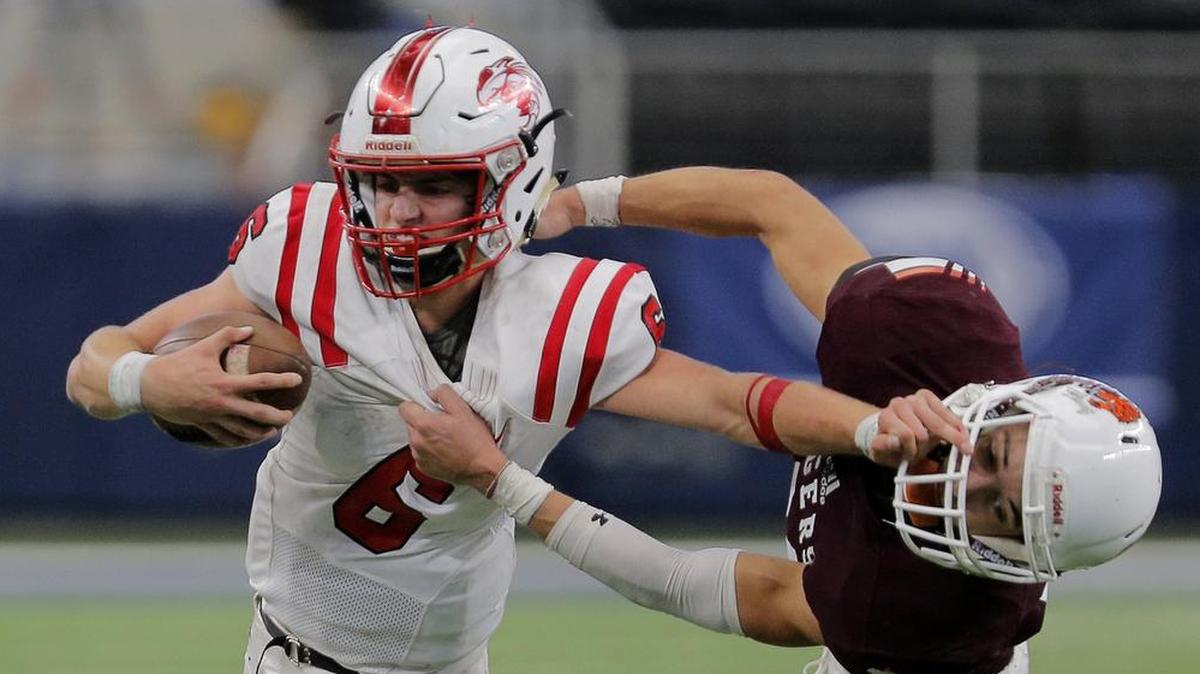 Muenster quarterback Parker McGrew stiff-arms Trenton Soto, of Tenaha, as Muenster wins over Tenaha 27-20 for the Conference 2A Division II state championship at AT&T Stadium, Thursday December 21, 2017.