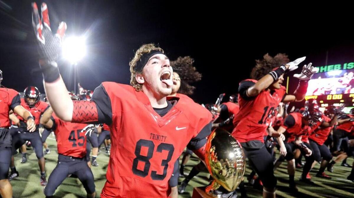 Trinity tight end Lane Polston (83) does the haka dance with the trophy and teammates after winning the Class 6A Division I Region I playoff game at Pennington Field on Friday.