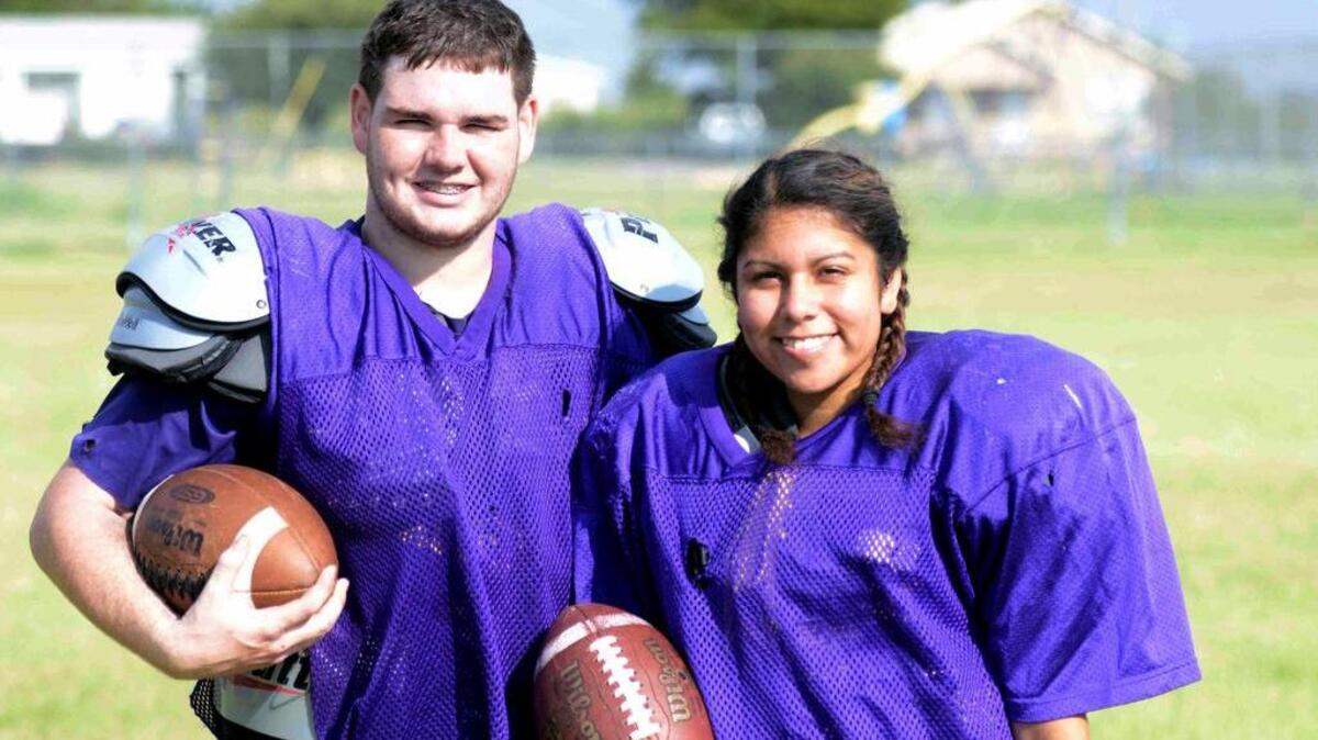 In this Aug. 10, 2016 photo, Harrold High School senior Brady Blakely, left, stands with teammate Olivia Perez in Harrold, Texas. Blakely is the primary reason Perez decided to try and help the Harrold High football team salvage their season. Blakely wanted to have one last year to play football to honor his father, who passed away from cancer in November 2015. The team needed six players to compete and only had five before Perez.