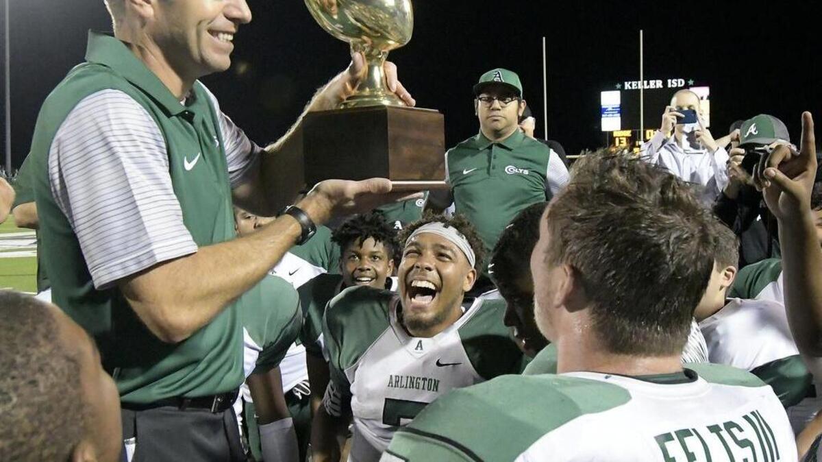 Arlington Colts head coach Scott Peach and his team celebrate after they beat Fossil Ridge 27-13 in the 2017 playoffs.