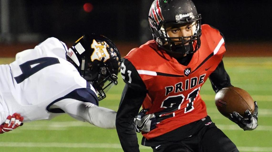 Colleyville Heritage receiver Kamron Brown (21) attempts to evade Arlington Heights defender Darius Williams in a 2016 game. Brown is committed to Texas A&M.