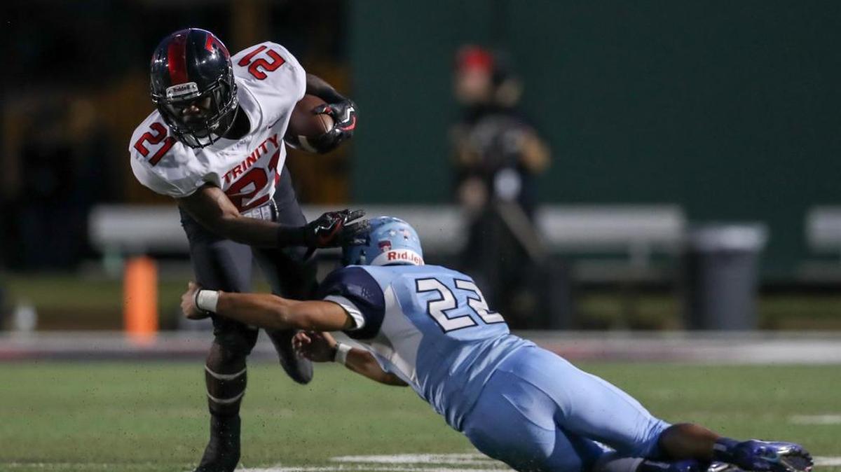 Trinity running back Courage Keihn (21) tries to elude L.D.Bell defensive back Michael Saavedra (22) on Oct. 19.