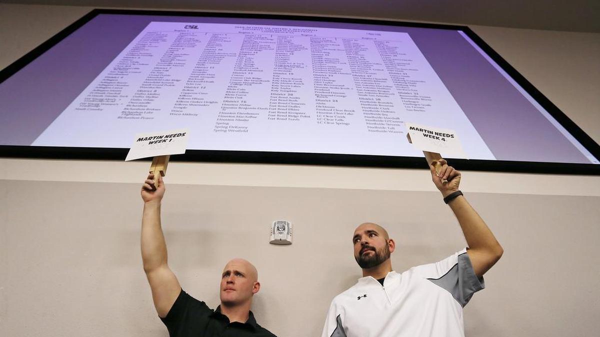 Arlington Martin coaches Jake Sharum and Adley Eshraghipour hold up signs seeking to fill open games during UIL realignment at Birdville ISD Fine Arts/Athletic Complex, Thursday, February 1, 2018.